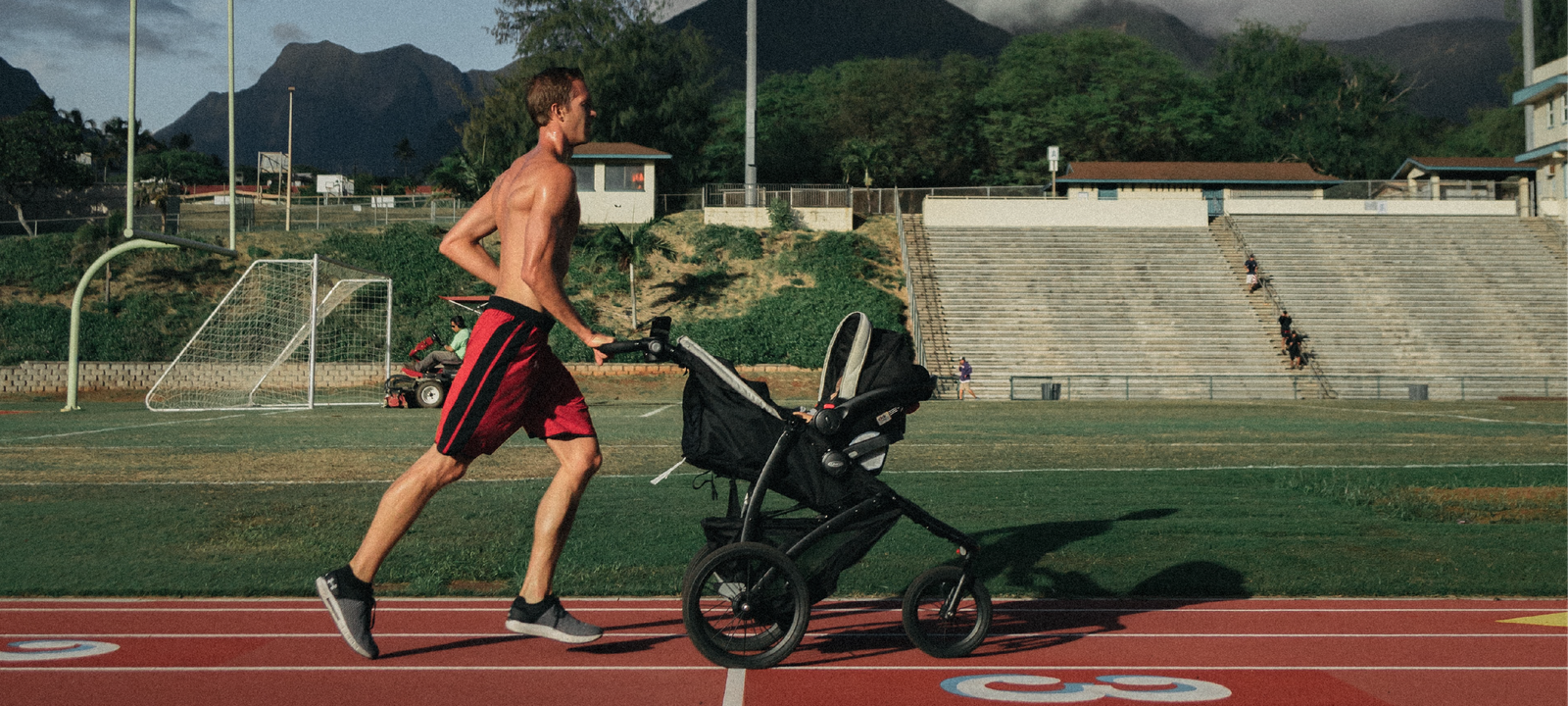 a daddy running with baby stroller in the stadium